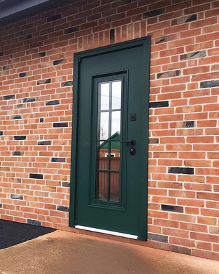 Зеленая дверь в кирпичном доме